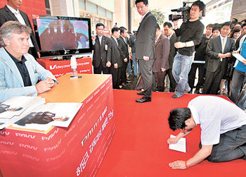 2006 독일 월드컵에서 한국의 16강 진출에 대한 염원일까. 17일 서울 중구 소공동 롯데백화점 본점에서 삼성전자 주최로 열린 사인회에서 한 팬이 거스히딩크 전 한국축구대표팀 감독에게 큰절을 하고 있다. 박영대 기자