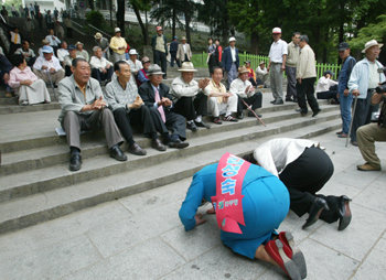 큰절 올리고…5·31지방선거의 공식선거운동에 돌입한 18일 광주 남구 사직동 광주공원에서 한 후보자가 거리 유세를 하다가 노인 유권자에게 큰절을 올리고 있다. 광주=이종승 기자