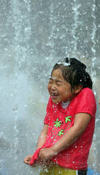 더운 초여름 날씨가 계속된 21일 오후 서울 상암동 주경기장옆 분수장을 찾은 어린이들이 쏟아지는 물줄기 사이에서 장난을 치고 있다[연합]