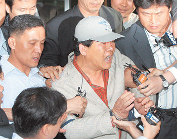 구치소로 향하는 지씨한나라당 박근혜 대표에게 흉기를 휘둘러 살인미수 등의 혐의로 구속영장이 발부된 지충호 씨(가운데)가 23일 오후 수감 장소인 서울 영등포구치소로 가기 위해 서울서부지검을 떠나고 있다. 지 씨는 검찰이 편파 수사를 했다고 기자들에게 외쳤다. 연합뉴스