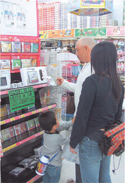 성인 고객이 뇌 마사지용 게임기를 시연하고 있다. 왼쪽 사진들은 인기를 끌고 있는 성인용 장난감.