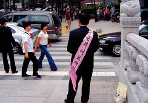 2005년 10월 서울 청계천 인근에서 ‘박근혜 대표 애인’이란  어깨띠를 두른 50대 남자가 행인들에게 유인물을 나눠주고 있다. photoro.com 제공