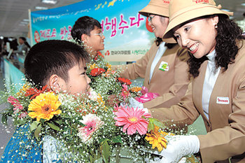 지난달 25일 제주공항에서 한국야쿠르트 직원들이 코시안 가족을 환영하며 꽃다발을 걸어 주고 있다. 사진 제공 한국야쿠르트