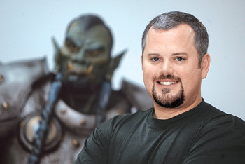 8일 방한한 세계 최대 온라인 게임 개발회사 블리자드의 최고운영책임자 폴 샘스 부사장이 자사의 게임 ‘WOW’에 등장하는 캐릭터의 모형 앞에서 포즈를 취하고 있다. 사진 제공 블리자드