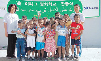 이라크 내 ‘평화학교’ 완공식장에서 손을 흔들며 웃는 어린이들. SK텔레콤은 2003년 8월 국제기아대책기구와 함께 이라크 주요 도시에서 평화학교 재건 사업을 벌였다.