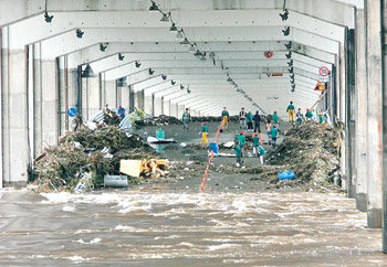 물 빠지는 잠수교 서울 용산구청 직원들이 18일 폭우에 떠내려와 잠수교에 쌓인 쓰레기를 치우고 있다. 변영욱 기자