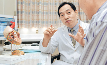 박표원 삼성서울병원 심장혈관센터장이 심장판막증 환자인 김상진 씨에게 심장 구조에 대해 설명하고 있다. 이진한 기자