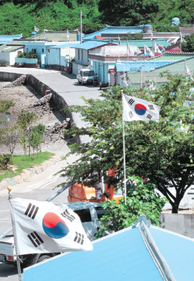 1년 365일 태극기가 휘날리는 전남 여수시 묘도동 온동마을 풍경. 온동마을은 하루 평균 100여 척씩 마을 앞 광양제철소와 광양항 컨테이너 부두 등을 오가는 외국 선박들에 태극기를 알리는 외교사절 구실을 하고 있다. 여수=박영철  기자