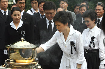 박근혜 한나라당 전 대표(앞)가 15일 서울 동작구 동작동 국립묘지에서 열린 어머니 육영수 여사 32주기 추도식에서 동생 근령 씨(오른쪽), 지만 씨 부부가 지켜보는 가운데 분향하고 있다. 김경제기자