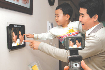 SK텔레콤의 ‘디지털 액자’ 서비스를 이용하면 휴대전화로 찍은 사진을 집에 있는 디지털 액자에 올릴 수 있다. 사진 제공 SK텔레콤