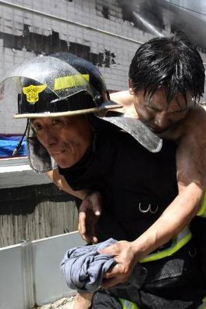 화재현장 시민구조 1일 서울 종로 쥬얼리시티 신축공사현장에서 화재로 부상자가 발생하자 소방대원이 구출하고 있다. [연합]