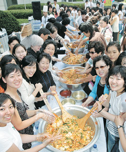 1일 설립 100주년을 맞은 연세대 간호대 학생과 교수, 동문 등 300여 명이 대형 양푼에 비빔밥을 만들어 서로 먹여 주는 행사를 하고 있다.안철민 기자