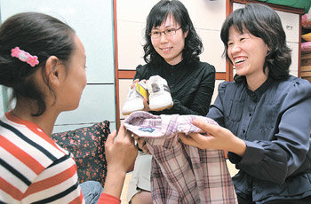 기아대책 회원들이 19일 오후 한 저소득층 결손가정을 찾아가 후원자가 보내준 성금으로 마련한 운동화와 추석빔을 전달하고 있다. 홍진환  기자