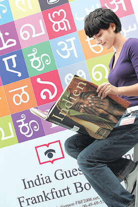 ‘제58회 프랑크푸르트 국제 도서전’ 개막 하루 전인 2일 한 여성이 올해 주빈국 인도를 나타내는 포스터 앞에서 인도에 관한 책을 살펴보고 있다. 도서전에는 100여 개국 7200여 출판사가 참가해 책의 성찬을 마련한다. 프랑크푸르트=AFP 연합뉴스