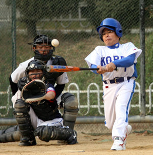 15일 서울 광진구 자양중학교에서 열린 국내 최초의 지체장애인 야구팀과 여성 야구팀 간의 대결에서 장애인팀의 한 선수가 안타를 치고 있다. 안철민  기자