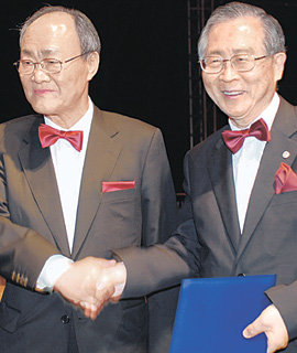 천신일 세중나모여행 회장(왼쪽)이 박찬모 포스텍 총장에게 대학 발전과 인재 양성에 써 달라며 8억7000만 원 상당의 자사 주식 9만 주를 기부한 뒤 악수하고 있다. 포항=연합뉴스