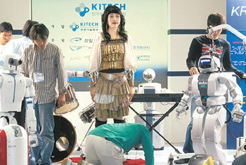 18일 ‘로보월드 2006’에서 가수로 데뷔하기로 한 연예인 로봇 ‘에버투-뮤즈’(가운데)를 행사 관계자들이 점검하고 있다. 그러나 에버투-뮤즈는 부품 고장으로 정상적으로 작동하지 않았다. 최혁중 기자