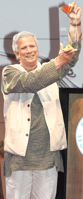 2006년 서울평화상 수상자인 무하마드 유누스 그라민은행 총재가 19일 서울 신라호텔에서 열린 시상식에서 감사의 인사와 함께 상패를 들어 보이고 있다. 유누스 총재는 올해 노벨 평화상 수상자로도 선정됐다. 박영대  기자