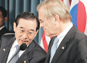 박자 안 맞는 두 국방 윤광웅 국방부 장관(왼쪽)과 도널드 럼즈펠드 미국 국방장관이 21일 오전(한국 시간) 미 워싱턴 국방부에서 열린 제38차 한미 연례안보협의회(SCM) 직후 공동 기자회견 도중 얘기를 나누고 있다. 워싱턴=연합뉴스