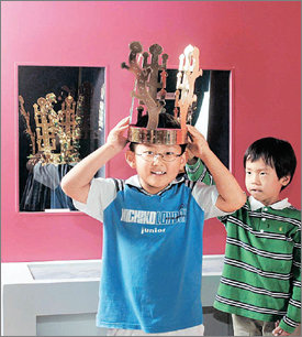 한 어린이가 국립중앙박물관 내 ‘어린이 박물관’에서 모형 금관을 쓰고 즐거워하고 있다. 동아일보 자료 사진