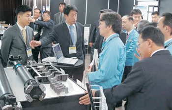 26일 일본 사이타마 현 닛산디젤 본사에서 제1회 ‘한국 상용차부품 전시회 2006’이 열렸다. 현대모비스 직원이 일본 닛산 구매 담당자에게 국산 부품을 소개하고 있다. 사진 제공 현대모비스