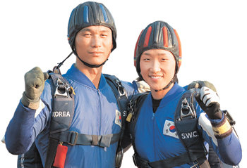 파이팅! 지난달 27일 오후 경기 성남시 특전사 헬기 계류장에서 특전사 소속 김만선 상사(왼쪽)와 오은순 중사 부부가 안전 낙하를 다짐하고 있다. 성남=황유성 기자