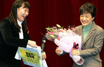 박근혜 전 한나라당 대표(오른쪽)가 6일 오후 충남 천안시 단국대 천안캠퍼스에서 강연을 하기 전에 학생 대표에게서 꽃다발과 선물을 받고 즐거워하고 있다. 천안=연합뉴스
