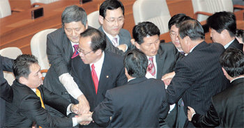 몸싸움14일 저녁 국회 본회의장 단상을 점거한 한나라당 의원들이 내건 플래카드를 열린우리당 서갑원 의원(왼쪽에서 두 번째)이 기습적으로 뜯어내자 양당 의원들이 서로 빼앗으려고 몸싸움을 벌이고 있다. 김경제 기자