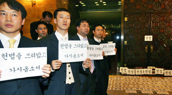 “헌법을 밟고 가시오” 한나라당 당직자와 보좌진들이 15일 전효숙 헌법재판소장 후보자의 임명동의안 처리를 막기 위해 국회 본회의장 입구에서 구호가 적힌 종이카드를 들고 농성을 벌이고 있다. 한나라당 의원들은 이틀째 국회 본회의장 의장석을 점거한 채 철야농성을 벌였다. 신원건 기자