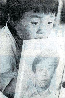 5·18민주화운동 직후 아버지의 영정을 안고 있는 다섯 살 때의 조천호 씨. 동아일보 자료 사진