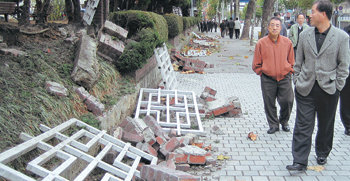 23일 오전 대전 중구 선화동 충남도청 앞 인도. 주변을 오가는 시민들이 전날 열린 한미 자유무역협정(FTA) 반대시위로 불에 타고 파손된 도청 담장과 뜯겨 나간 울타리를 바라보고 있다. 대전=지명훈 기자