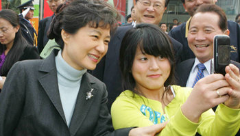 박근혜 전 한나라당 대표가 지난달 30일 중국 칭다오의 한국 기업인 세정아리안 홍보관 앞에서 젊은 중국 여성과 휴대전화로 사진을 찍고 있다. 칭다오=국회사진기자단