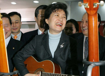 한나라당 박근혜 전 대표가 지난달 30일 중국 칭다오의 한국 기업 세정악기를 방문해 이 회사가 생산하는 기타로 연주를 시도하고 있다. 칭다오=국회사진기자단