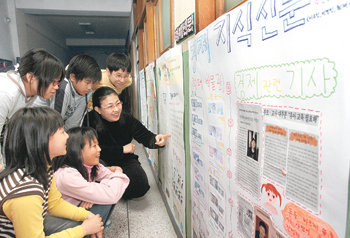 지난달 30일 서울 노원구 상계동 상경초등학교 학생들이 자신들이 직접 만든 경제신문을 보며 선생님과 이야기를 나누고 있다. 홍진환 기자