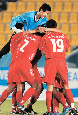 북한 축구선수들이 일본을 2-1로 꺾고 극적으로 8강 진출을 확정지은 뒤 서로 얼싸안으며 환호하고 있다. 북한은 10일 오전 1시 한국과 4강 티켓을 놓고 남북 대결을 벌이게 됐다. 도하=연합뉴스