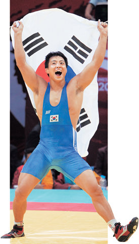 레슬링 그레코로만형 84kg급 결승에서 김정섭이 우승을 확정지은 직후 한국 노래가 나오자 태극기를 든 채 덩실덩실 춤을 추고 있다. 도하=강병기  기자