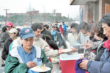 미국 워싱턴 인근 애넌데일에서 한인 자원봉사단체 굿스푼선교회가 운영하는 무료 점심에 남미계 일용 노동자들이 줄을 서서 김이 모락모락 나는 수프와 밥, 빵을 받고 있다. 애넌데일=이기홍  특파원