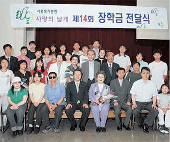 마담포라 이철우 명예회장이 1992년 설립한 사회복지법인 ‘사랑의 날개’가 장애인들에게 장학금을 전달했다. 사진 제공 마담포라