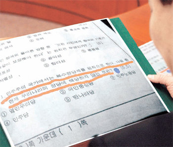 한나라당의 한 당직자가 20일 최고위원 중진 연석회의에서 한나라당을 ‘딴나라당’으로 비하한 출처 불명의 고교 사회과목 시험지 사진을 보고 있다. 한나라당은 인터넷에 떠돌고 있는 이 시험문제에 대해 교육부의 조사를 요구했다. 김경제 기자