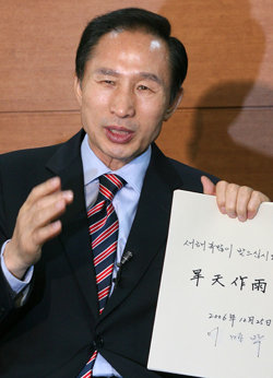 송년 회견 한나라당 이명박 전 서울시장이 25일 서울 종로구 견지동 사무실에서 송년 기자회견을 하면서 ‘한천작우’라고 쓴 종이를 들어 보이며 뜻을 설명하고 있다.