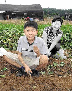 지난해 여름 아들 진수(왼쪽)와 어머니 권혁금 씨(오른쪽)가 일광자연농원에서 고구마 캐기 현장체험학습을 하고 있는 모습이다. 진수 가족사진은 몽땅 불에 타버려 없어지고 이 사진은 사직중학교에서 유일하게 보관하고 있는, 아들 진수와 어머니가 함께 찍은 사진이다.