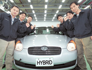 현대·기아자동차 연구원들이 하이브리드카인 ‘베르나 하이브리드’에 둘러서서 기술 개발 결의를 다지고 있다. 사진 제공 현대자동차