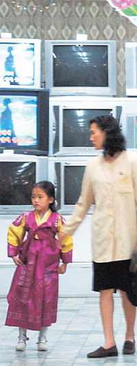 평양의 한 백화점에 진열된 외제 TV들을 둘러보는 북한 주민들. 불과 10년 전까지만 해도 북한에는 ‘대동강’ 상표 등 몇몇 종류의 TV밖에 없었으나, 최근 몇 년간 무역회사들이 우후죽순처럼 생기면서 각종 외제 가전제품이 대량으로 수입되고 있다. 동아일보 자료 사진