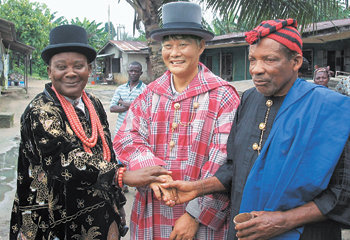 2003년 8월 나이지리아 하코트 항의 에자마 커뮤니티에서 명예추장으로 추대된 김우성 대우건설 차장(가운데)이 대추장인 아이작 아그바라 씨(왼쪽) 등과 기념촬영을 하고 있다. 동아일보 자료 사진