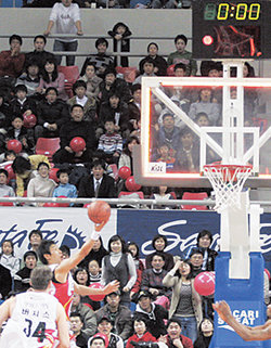 모비스 양동근(왼쪽 위)이 14일 오리온스와의 경기에서 85-85 동점이던 4쿼터 종료 직전 필사적으로 레이업슛을 던지고 있다. 이 골은 버저비터로 인정돼 결승골이 됐지만 실제로는 사진에서 나타나듯 볼이 양동근의 손을 떠나기 전에 골대 위쪽 계시기는 이미 경기가 종료된 것을 나타내고 있다. 동아일보 자료 사진