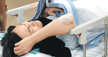 응급실의 부장판사 15일 오후 서울 송파구 잠실동 자택 앞에서 판결에 불만을 품은 전직 대학교수 김명호 씨가 쏜 석궁 화살에 배를 맞은 박홍우 서울고법 부장판사가 서울 강남구 서울의료원 응급실에서 간단한 치료를 받은 뒤 누워 있다. 박영대 기자