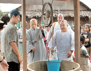 지구촌공생회 대표이사 송월주 스님(왼쪽에서 두 번째)이 2005년 12월 ‘생명의 우물 1000’ 프로젝트의 하나로 캄보디아 캄포트 주의 한 마을에 마련된 우물에서 물을 긷고 있다. 사진 제공 지구촌공생회