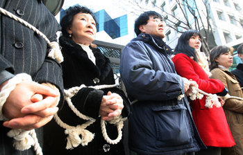 “외교부는 각성하라” 북한인권단체 회원과 탈북자 등이 18일 서울 종로구 도렴동 외교통상부 청사 앞에서 밧줄로 몸을 묶은 채 기자회견을 열어 탈북자들의 한국행을 도운 혐의로 체포돼 4년여간 중국에서 수감생활을 한 최영훈 씨를 방치한 외교부 담당영사의 문책 등을 요구하고 있다. 사진 제공 납북자가족모임