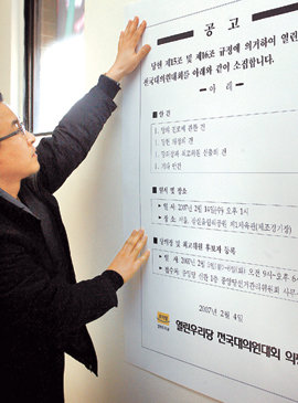 분당위기속 전당대회 공고문 20명 안팎 의원의 집단 탈당이 임박한 것으로 알려진 4일 열린우리당의 한 당직자가 서울 영등포 당사 내 벽에 전당대회(전국대의원대회) 소집 공고문을 붙이고 있다. 전당대회는 14일 서울 잠실 올림픽 체조경기장에서 열린다. 연합뉴스