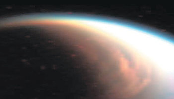 토성의 위성 타이탄의 북극에서 북위 62도까지 태양 광선이 비치는 쪽으로 거대한 구름이 보인다. 토성 궤도탐사선 카시니호가 지난해 12월 29일 찍은 가시광선 및 적외선 사진을 합성해 색을 입힌 것이다. 사진 출처 미국항공우주국